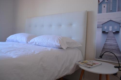 ein Schlafzimmer mit einem Bett und einem Tisch mit einem Buch in der Unterkunft Atlantic Residence in Caminha