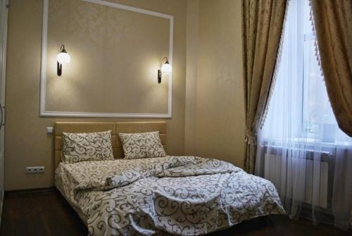 1 dormitorio con 1 cama, ventana y 2 luces en Nezhnyye Apartments, en Odessa