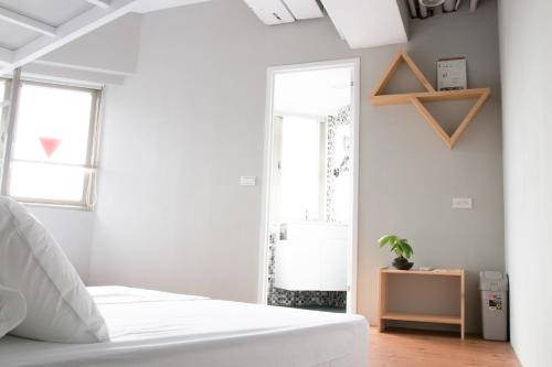 a bedroom with a white bed and a mirror at May Rooms Taipei Main Station in Taipei