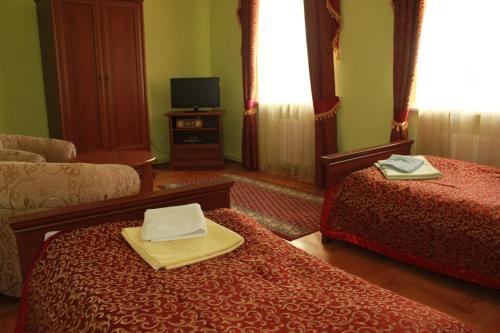 a hotel room with two beds and a tv at Pałac w Nosowie in Nosowo