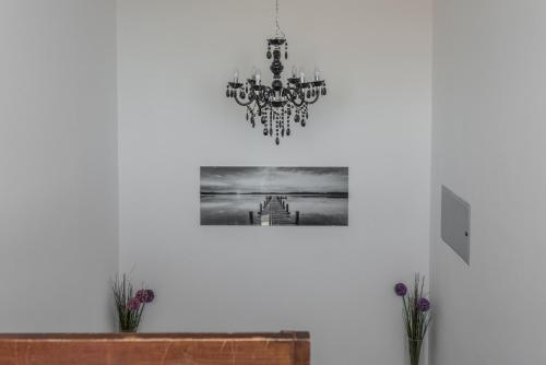 a chandelier hanging on a white wall with a picture at Apartments Bego Spa & Wellness in Crikvenica