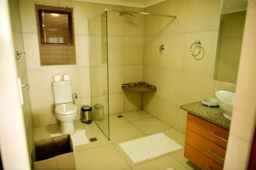 a bathroom with a shower and a toilet and a sink at Summer Place Umzumbe in Umzumbe