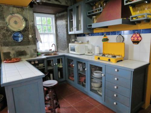 a kitchen with blue cabinets and a counter top at Casa Adega Alto do Passinho in Terra Alta