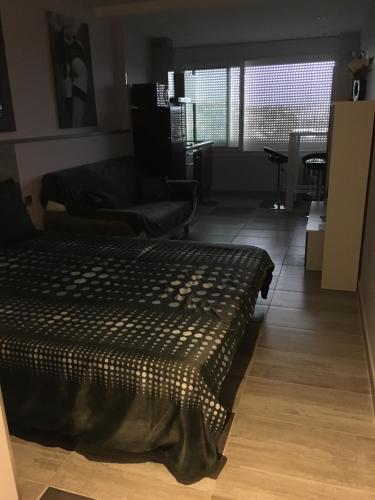 - un salon avec un lit installé sur du parquet dans l'établissement Village Naturiste Agde, au Cap d'Agde