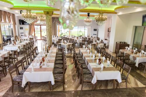 a dining room with tables and chairs and chandeliers at SPA Kompleks Raiski Kat in Dimitrovgrad