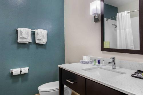 a bathroom with a sink and a toilet and a mirror at MainStay Suites in Big Spring