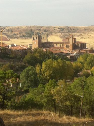 a view of a town with a castle and trees at Molino de Alcuneza Relais & Châteaux in Sigüenza