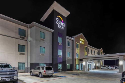 a sign for a hotel with a parking lot at MainStay Suites Big Spring North I-20 in Big Spring