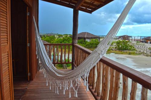 a hammock on a porch with a view of the ocean at Casa Dunas da Barrinha in Barrinha