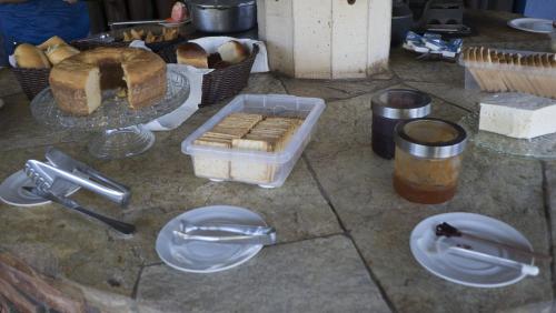 a table with some bread and plates on a counter at Pousada das Nascentes in Catas Altas