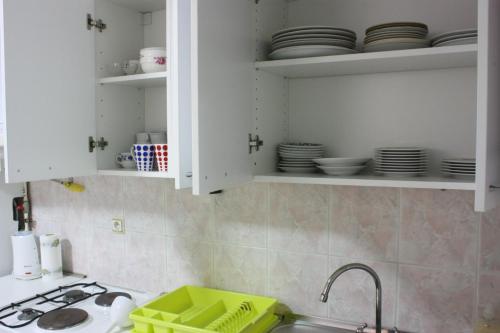 a kitchen with white cabinets and a sink and plates at Apartman Maksimir Relax Zagreb-75m2 in Zagreb