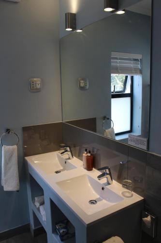 a bathroom with two sinks and a large mirror at Whale Rock Luxury Lodge in Hermanus