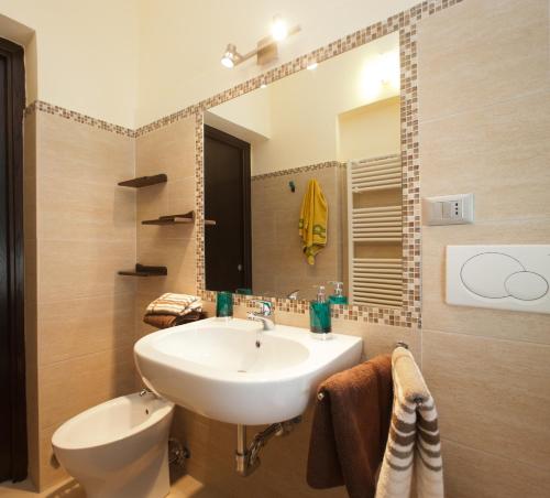 W łazience znajduje się umywalka, toaleta i lustro. w obiekcie B&B Al Calcandola w mieście Sarzana