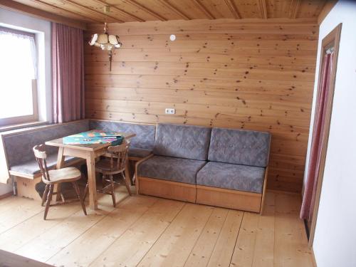 a dining room with a couch and a table at Ferienwohnungen Steidl in Innervillgraten