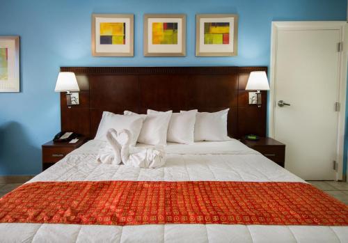 a bedroom with a large bed with a red blanket at Flamingo Express Hotel in Kissimmee
