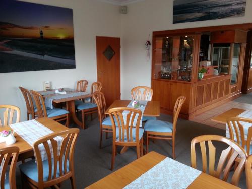 a dining room with wooden tables and chairs at Hotel das Möwenstübchen in Wremen