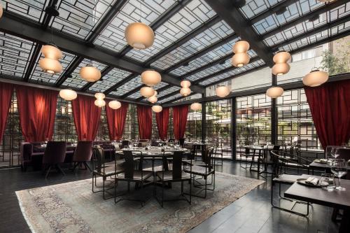 a restaurant with tables and chairs and red drapes at Fifty House Cellini in Milan