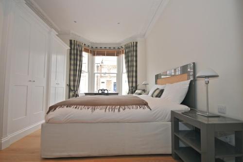 ロンドンにあるCanguroProperties - Gertrude Streetのベッドルーム(大型ベッド1台、窓付)