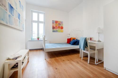 Habitación blanca con cama y escritorio. en Apartament w Centrum Olsztyna en Olsztyn