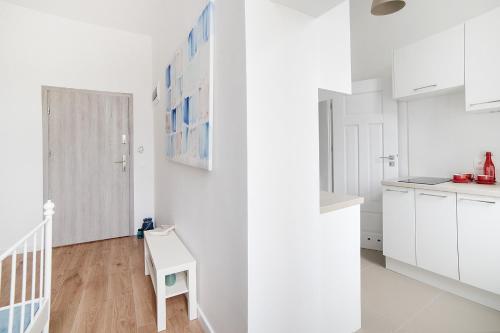 a white kitchen with white cabinets and a table at Apartament w Centrum Olsztyna in Olsztyn