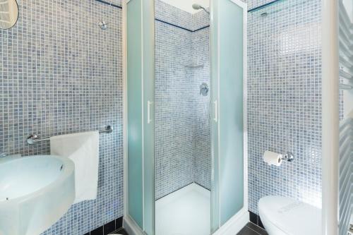 een badkamer met een douche, een toilet en een wastafel bij Hotel Tulipe Nazionale in Riccione