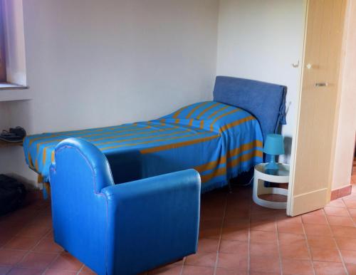 a small bedroom with a blue bed and a chair at Borghetto mare e limoni - by Sicania Experience in Santa Tecla