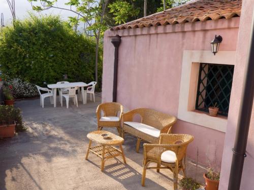 a patio with wicker chairs and tables and a table at Borghetto mare e limoni - by Sicania Experience in Santa Tecla