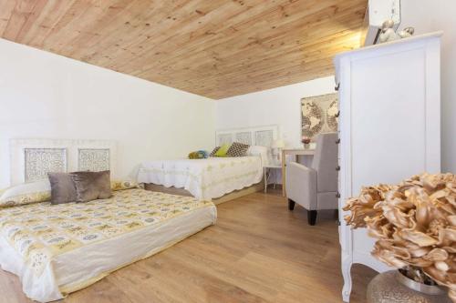 a bedroom with two beds and a table with a chair at Loft / Duplex with charming historic center. WIFI in Seville