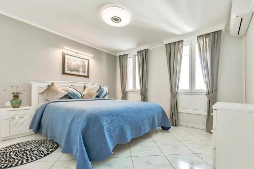 プラヤ・デ・ラス・アメリカスにあるParque Santiago 2 Penthouseの白いベッドルーム(青いベッド1台、窓付)