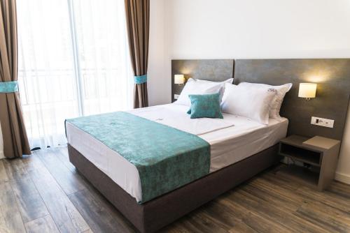 a bedroom with a large bed with a large window at B&B Amfora in Petrovac na Moru