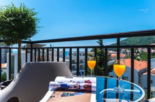 a table with two glasses of orange wine on a balcony at B&B Amfora in Petrovac na Moru