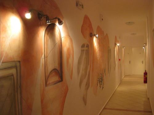 a hallway with many paintings on the wall at Manto Studios in Palaiochóra