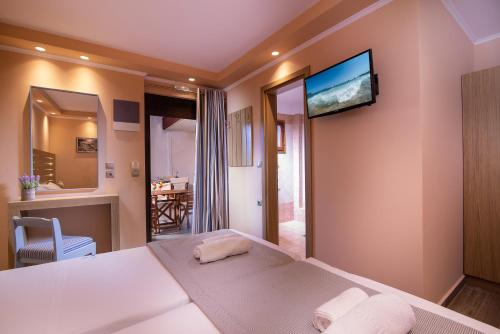 Hotel Pontos في سارتي: غرفة نوم بسرير وتلفزيون على الحائط