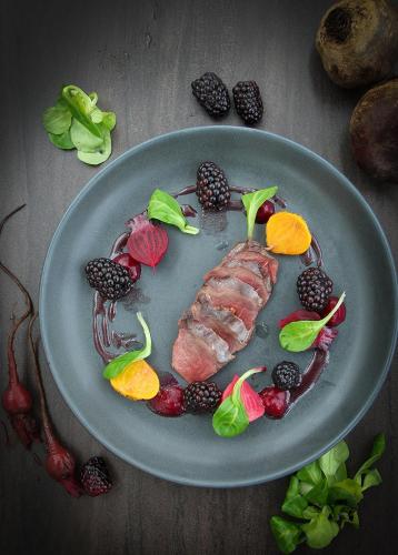a plate of food with meat and fruit on a table at The Barnsdale, Rutland in Oakham