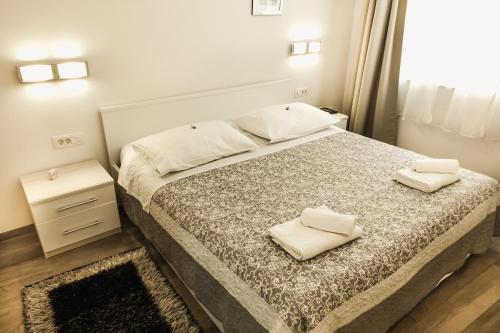 um quarto com uma cama com duas toalhas brancas em Old Square Apartment em Split