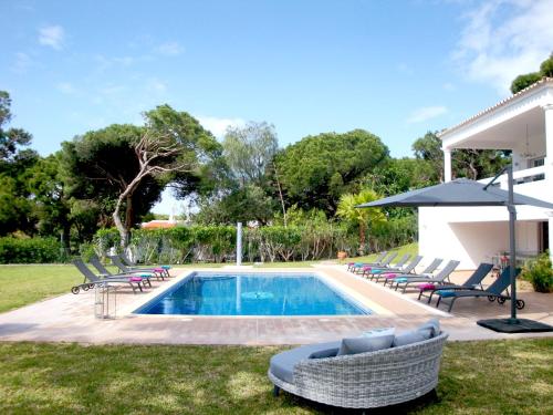 a swimming pool with lounge chairs and an umbrella at Fonte Santa by Check-in Portugal in Quarteira