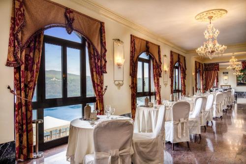 a row of tables in a room with windows at Hotel Castel Vecchio in Castel Gandolfo