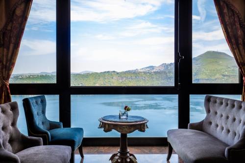 a room with two chairs and a table in front of a window at Hotel Castel Vecchio in Castel Gandolfo