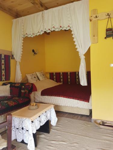 a bedroom with two beds and a couch and a table at Holiday home Zavičaj in Pluzine