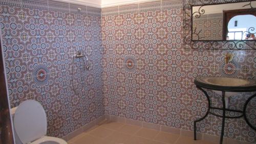 bagno con servizi igienici, lavandino e specchio di Kasbah Ait Bouguemez ad Agouti