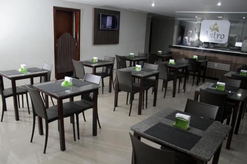 a restaurant with tables and chairs and a bar at Astro Palace Hotel in Uberlândia