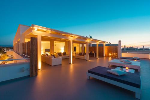 a rooftop deck with furniture and lights at night at Casa del Faro in Torre Canne