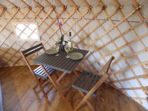 a table and two chairs in a yurt at La Cera Farm Camping B&B in Santa Teresa Gallura