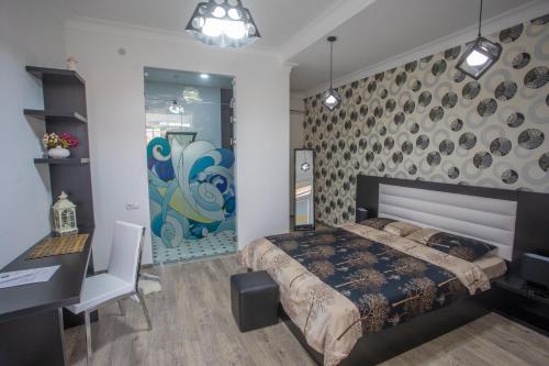a bedroom with a bed and a table and a desk at Hotel Paradise Road in Kutaisi