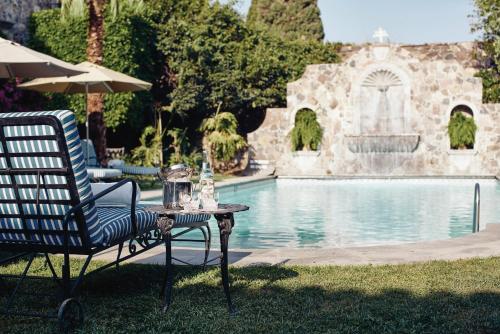 a table with a chair and an umbrella next to a pool at Casa de Sierra Nevada, A Belmond Hotel, San Miguel de Allende in San Miguel de Allende