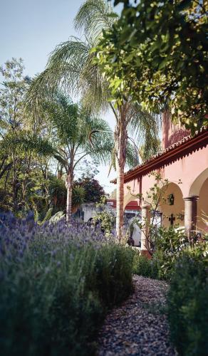 a garden with purple flowers in front of a building at Casa de Sierra Nevada, A Belmond Hotel, San Miguel de Allende in San Miguel de Allende