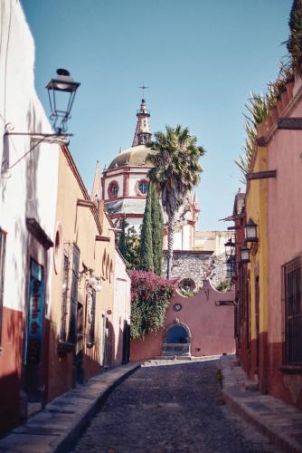 a street with a building with a clock tower at Casa de Sierra Nevada, A Belmond Hotel, San Miguel de Allende in San Miguel de Allende