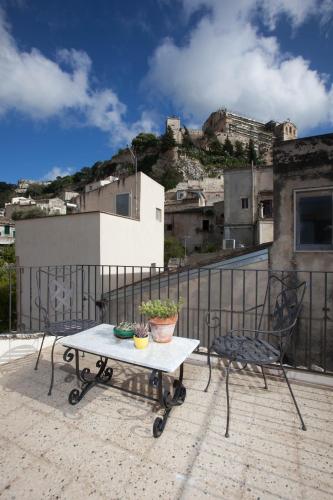 a table and a chair on a balcony at Terrazzo Vinicio in Scicli