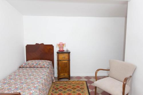 a bedroom with a bed and a chair at Terrazzo Vinicio in Scicli