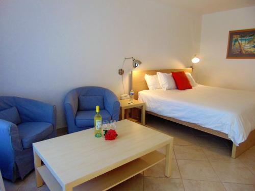 Cette chambre comprend 2 lits, des chaises bleues et une table. dans l'établissement Dolphin Key Resort - Cape Coral, à Cape Coral